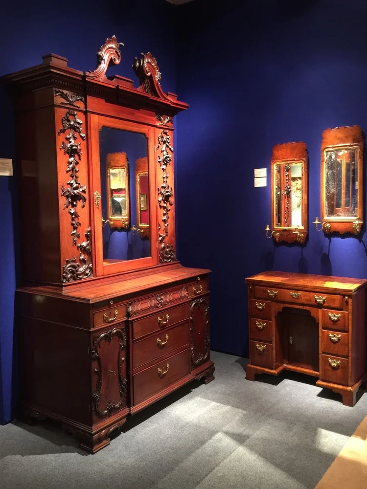 Wooden case pieces in a vignette from Hyde Park Antiques are made even more special with the cobalt blue walls. 