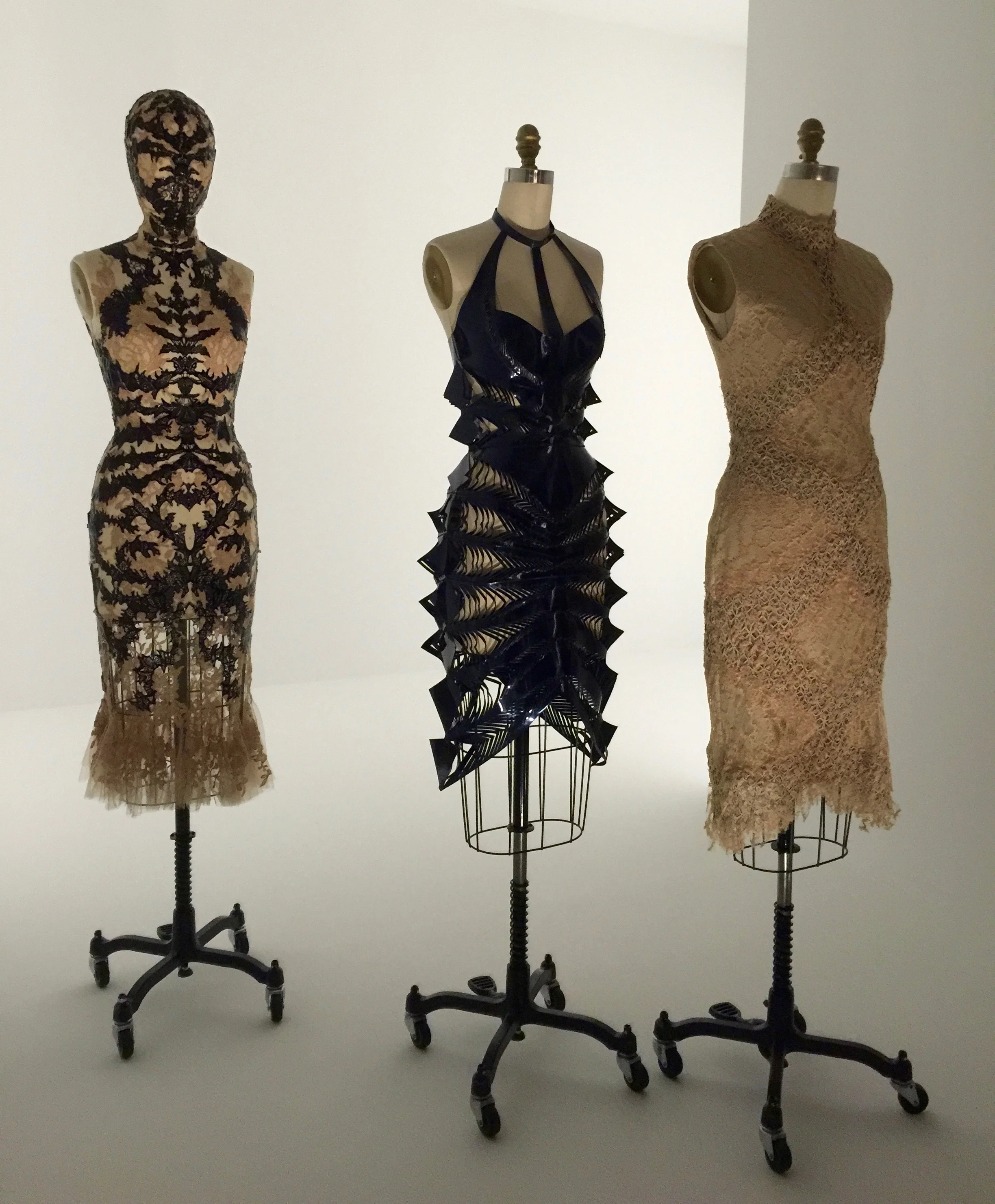 (l) ALEXANDER MCQUEEN, Sarah Burton DRESS, Spring/Summer 2012, pret-a-porter Machine and hand-sewn nude silk lace bonded with laser-cut black patent leather hand-sewn godets of nude silk tulle, hand-appliquéd with nude silk lace motifs (c) Iris van Herpen DRESS, Spring/Summer 2015, pret-a-porter Machine-sewn, laser-cut, bonded navy patent leather (r) Iris van Herpen DRESS, Spring/Summer 2016, pret-a-porter Machine-sewn, bonded nude silk twill and cotton plain weave with overlay of nude cotton lace handwoven with laser-cut nude leather appliqué