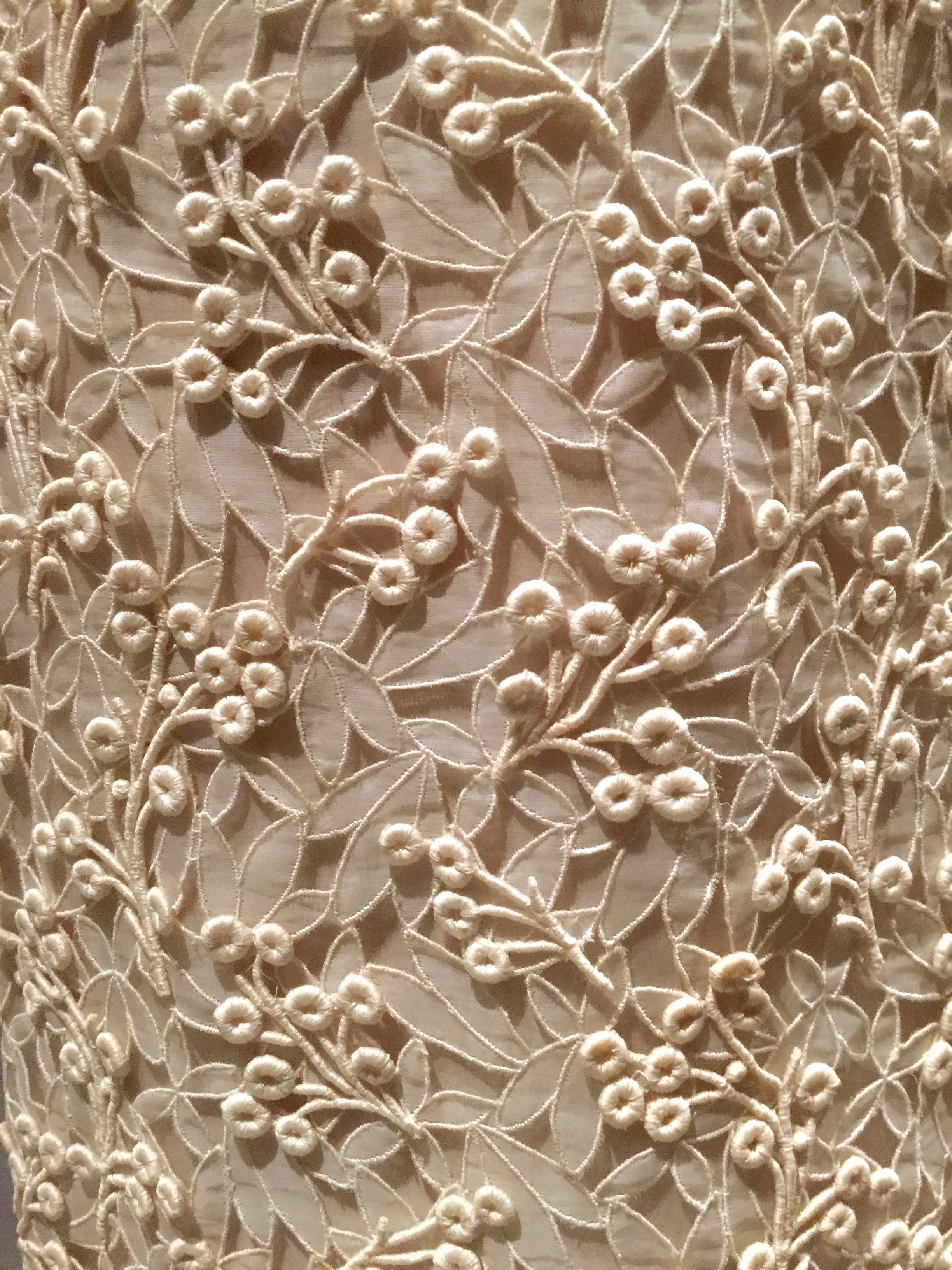 Detail of machine-embroidered cutwork hand-stitched with machine-embroidered guipure lace