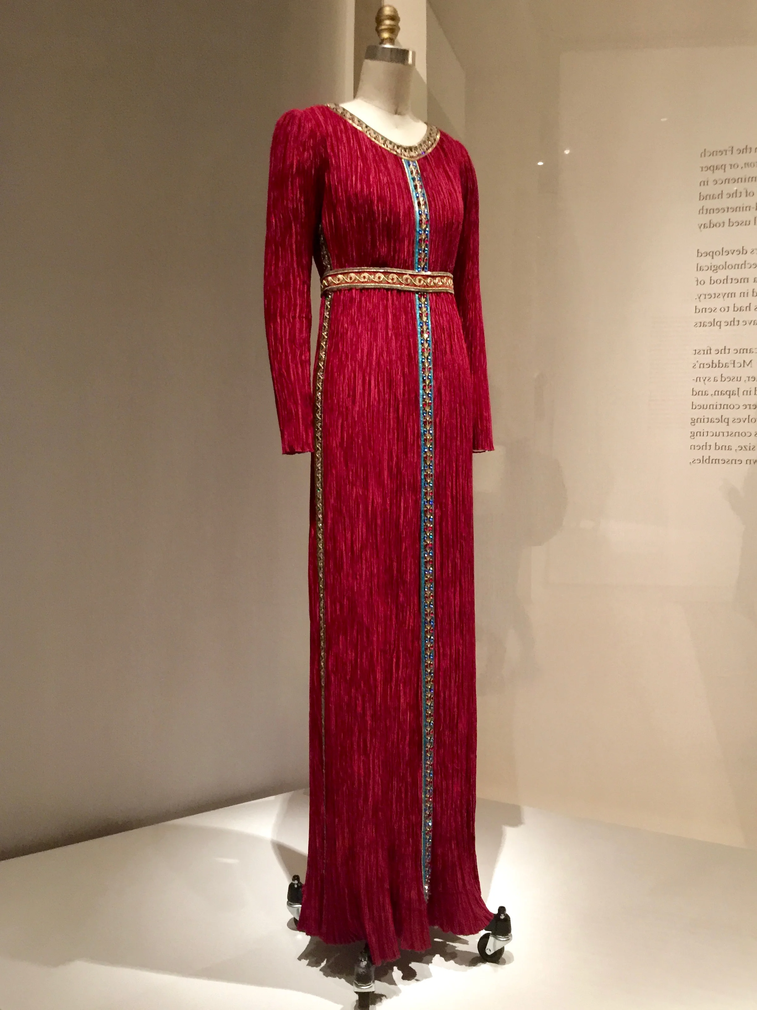 Mary McFadden DRESS, Ca. 1980, pret-a-porter Machine-sewn and "Marii" machine-pleated red polyester charmeuse, hand-stitched with hand-embroidered trims of sequins, bead, and gold metallic thread