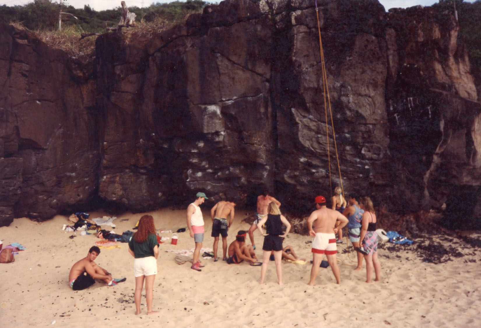 " When I first started bouldering at Waimea in 1986 climbers were rare. I would go early every Saturday and Sunday and make a trip along the wall with a garbage bag picking up all the fast wrappers, dirty diapers, and broken beer bottles then stake out a spot and boulder. I was using grey chalk. One day I came and there was white chalk. I was not alone. A few weekends later there was blue chalk. One day I was bouldering and a guy came along and said “are you the gray chalk guy? Yes says I, are you the white chalk guy? He asked me how I worked out some problem and that is how it started. Once I started putting up a top rope people would start coming off the beach to check it out and the next thing they knew they were in shoes and harness giving it a go. After a while there was a whole dedicated group of climbers bouldering on weekends."