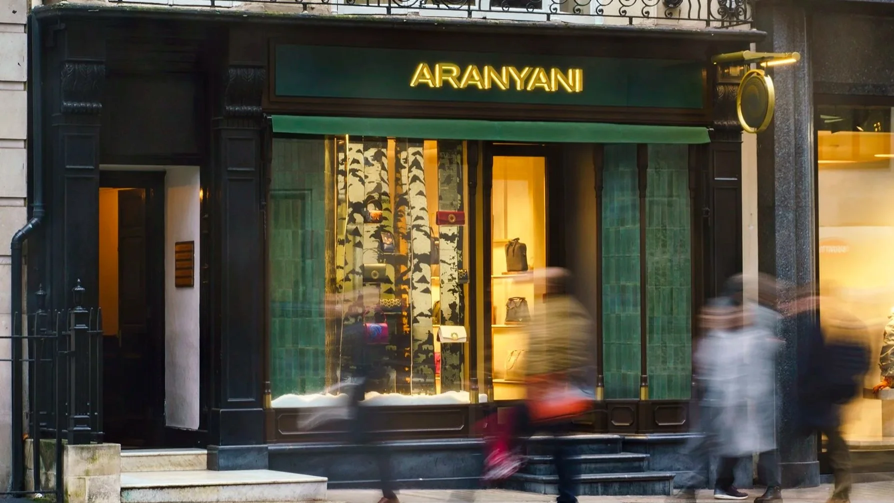 Aranyani luxury retail interior design - dark stone Mayfair facade with warm window light
