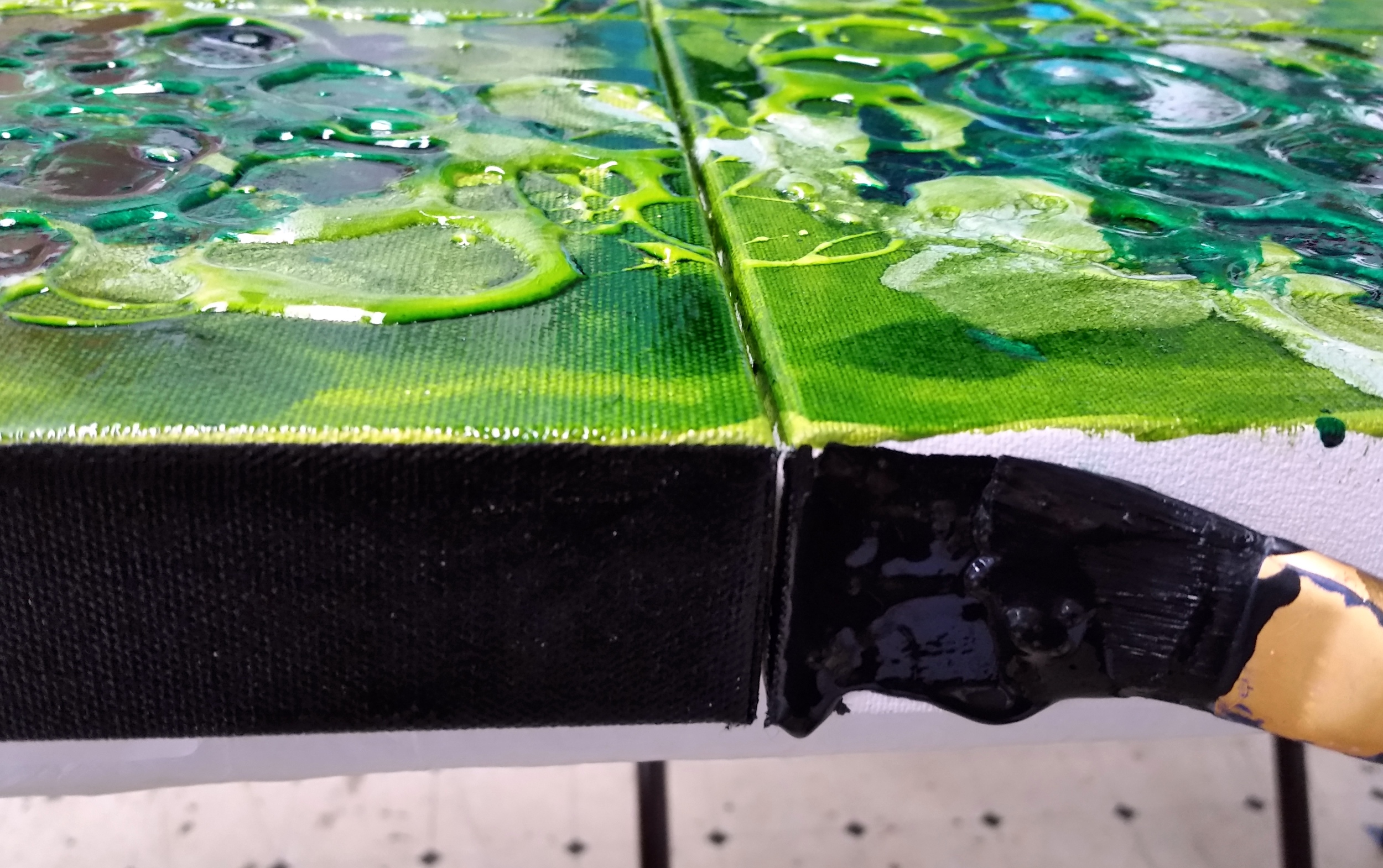 Painting the edge of "Floral Fantasy", resin and liquid oils, 16" x 16".