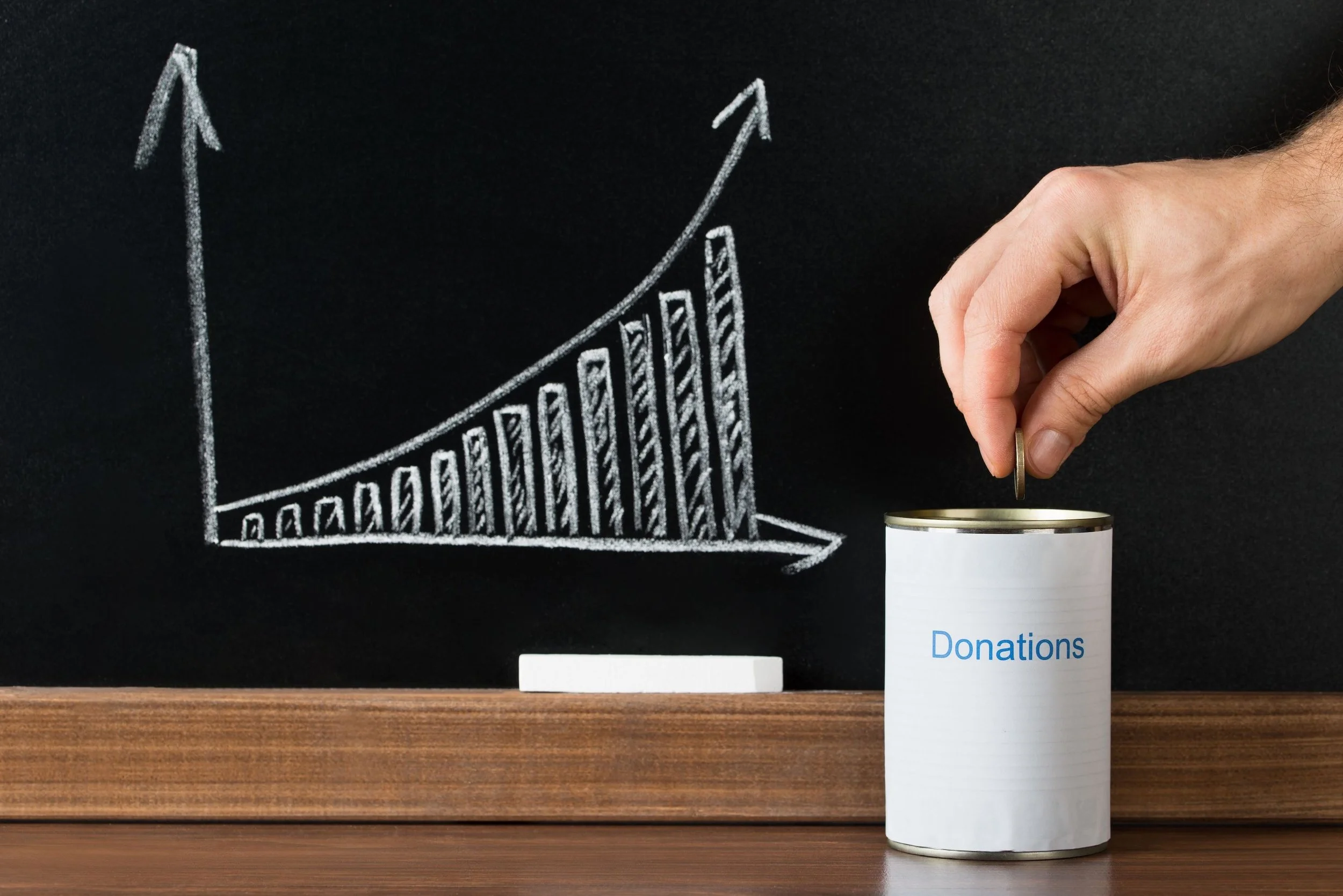 Close-up Of A Person Giving Donation Money Education Chart.jpeg