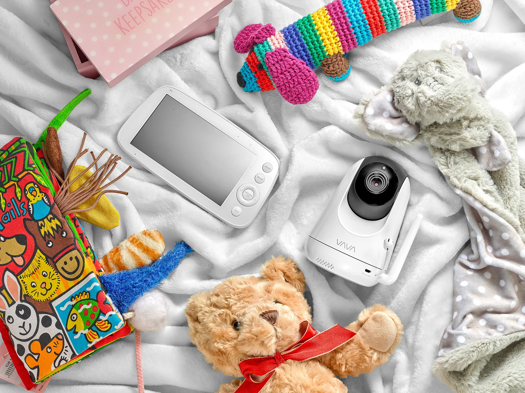 lifestyle product photography. Baby monitor and camera surrounded by lifestyle baby products on soft blanket. Created in London still life studio by chris howlett