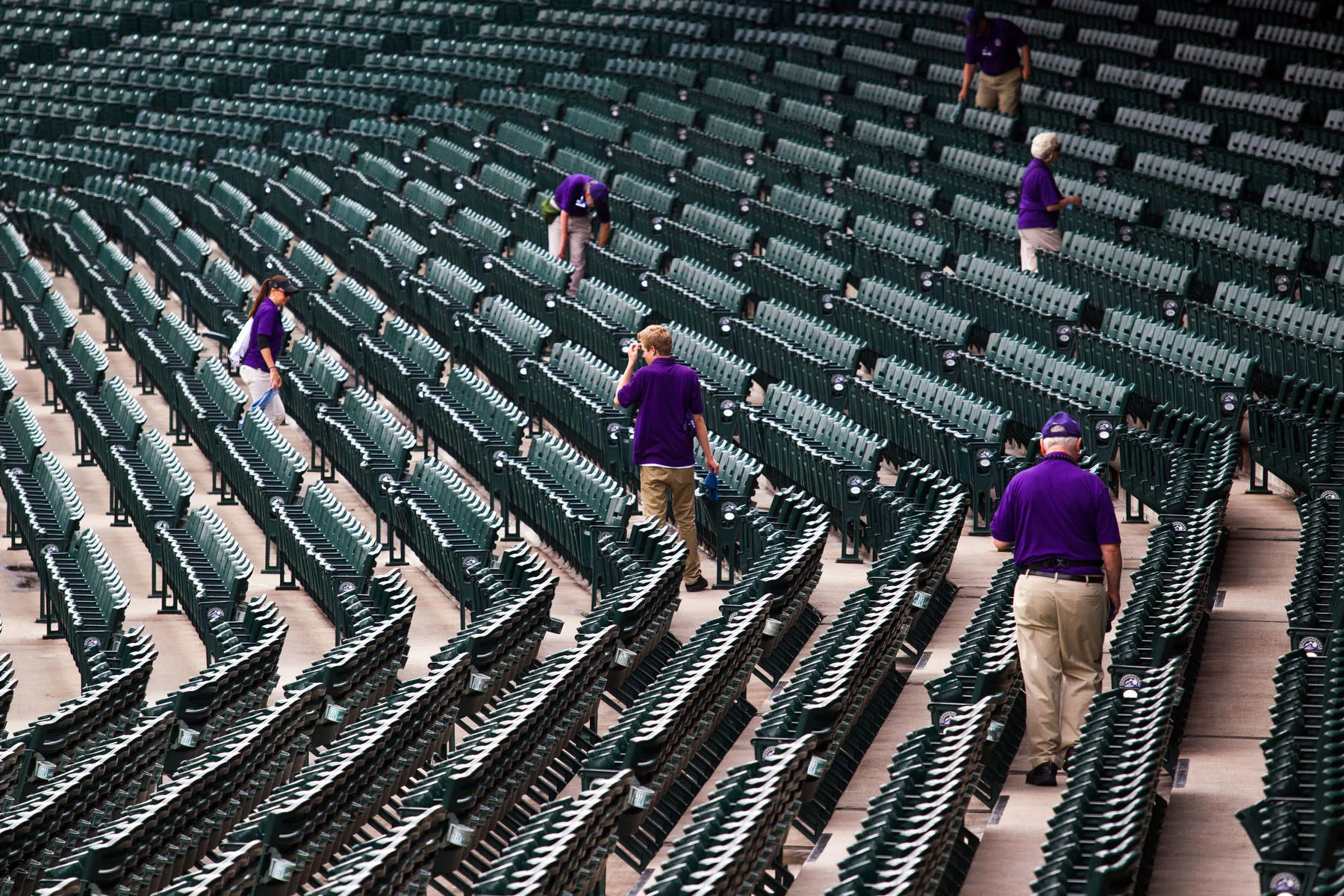 Ushers at Coors Field in Denver, CO walk the seats just after the gates open.