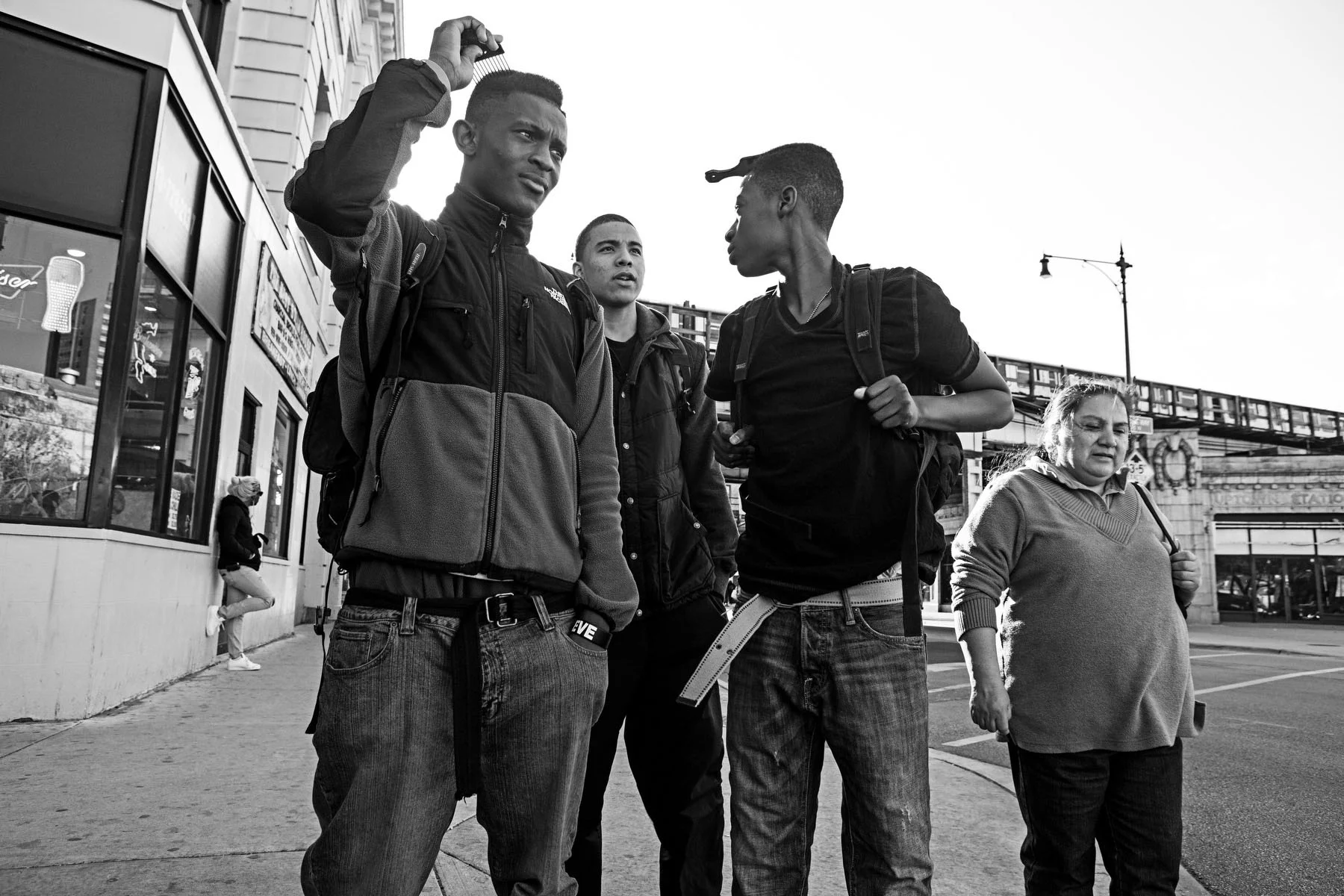 Augustin waits for a walk sign across the street from Uplift High School, where he and his teammates are headed to a workout. 
