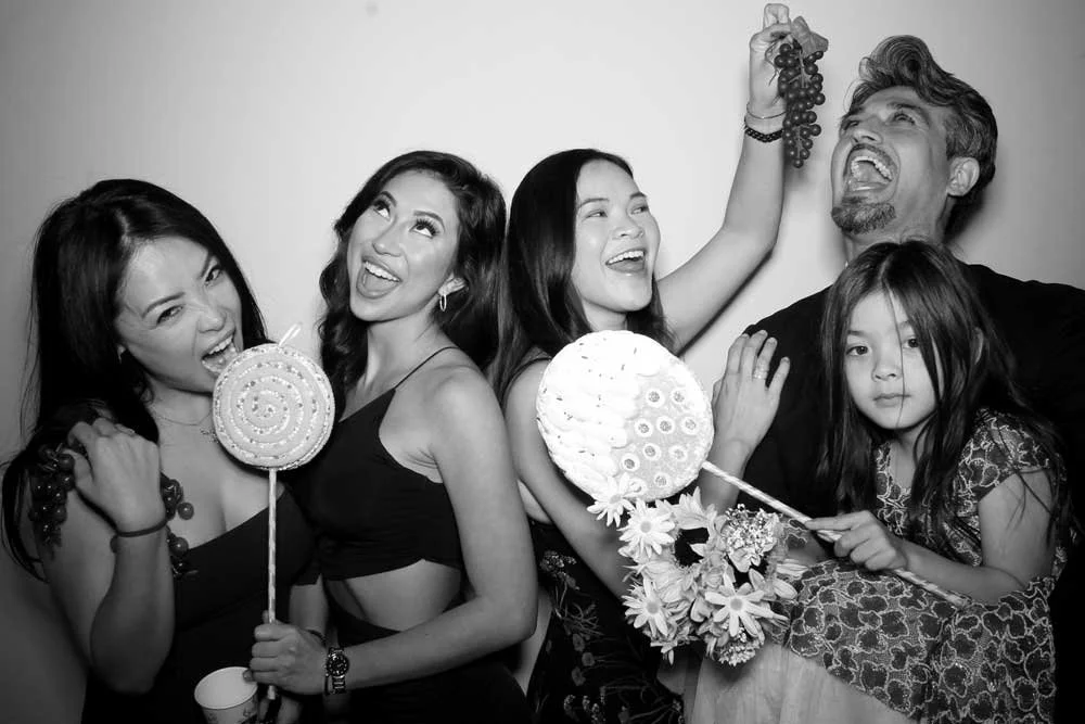 Group of guests in a black-and-white glam photo booth portrait
