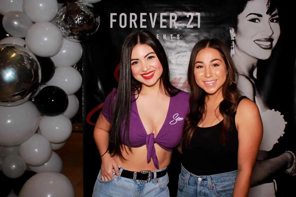Guests at a brand event photo booth with a custom backdrop and balloon installation