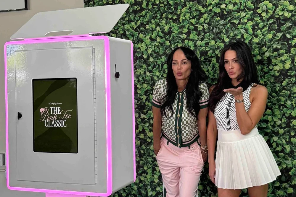 Open-air photo booth rental with studio lighting and an open backdrop at an Orange County event