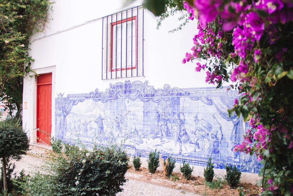 Tiled walls, colored doors, and blooming flowers