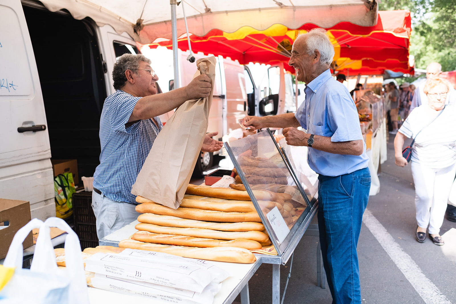 A man buys bread at the market in Arles