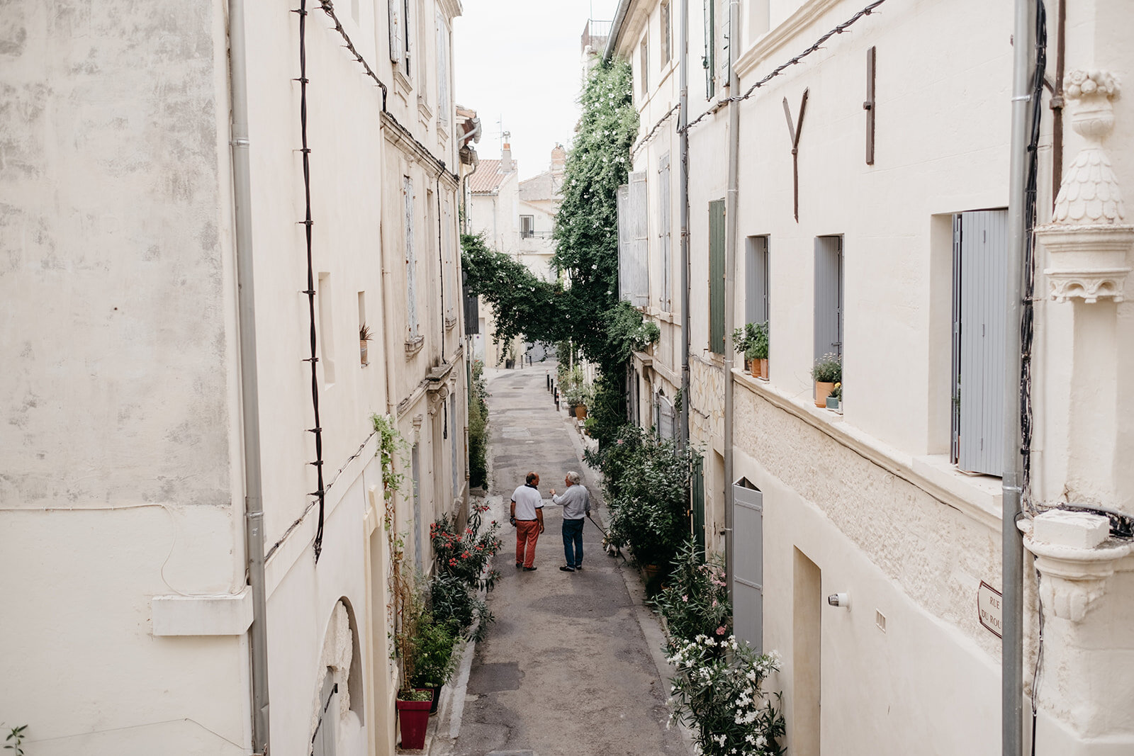 Two people walking down the street in Arles