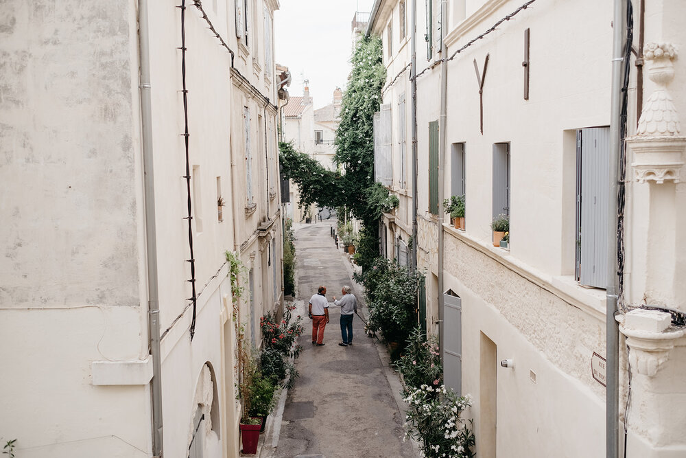 Two people walking down the street in Arles