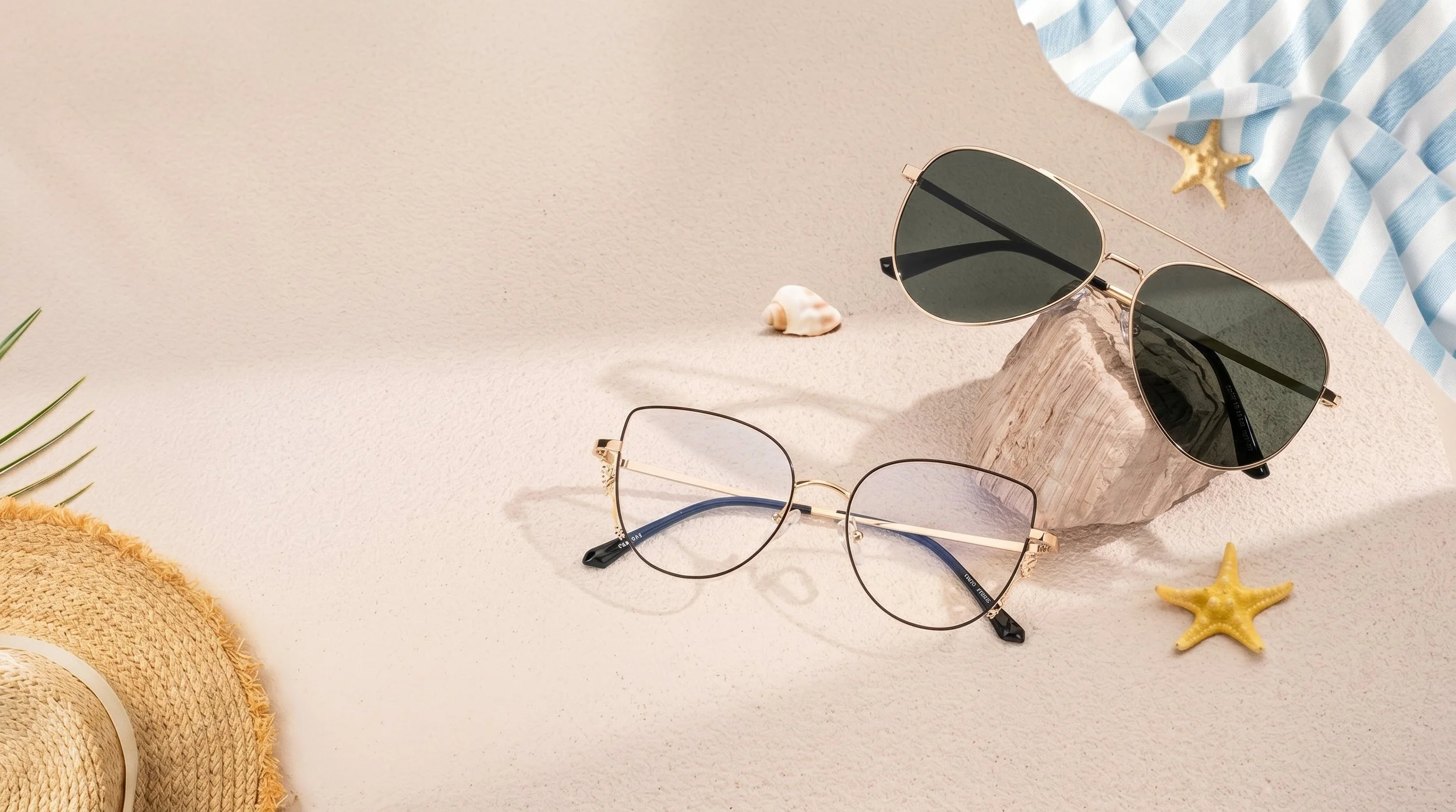 A pair of sunglasses and a pair of eyeglasses on a beige surface, with seashells, a starfish, a striped cloth, and a straw hat nearby.