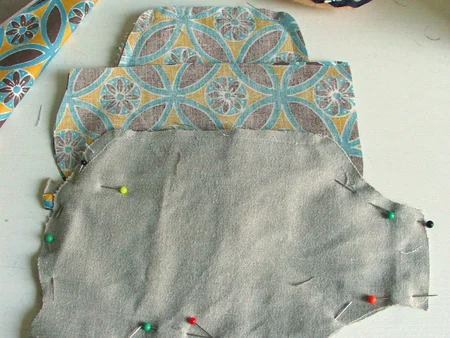 Step 3. Pin both sides together with the printed sides facing each other. Leave the top and the nose open. See picture. Put the tail in place. 