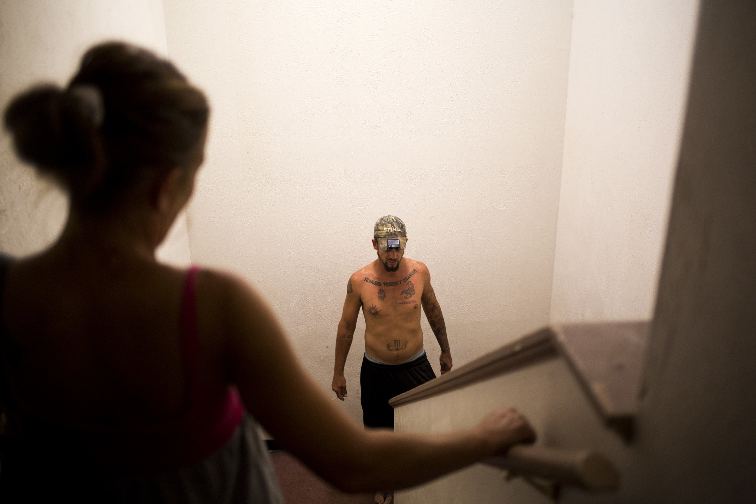 Chrissy and Troy in the stairwell of their new apartment building as they move their few belongings in.