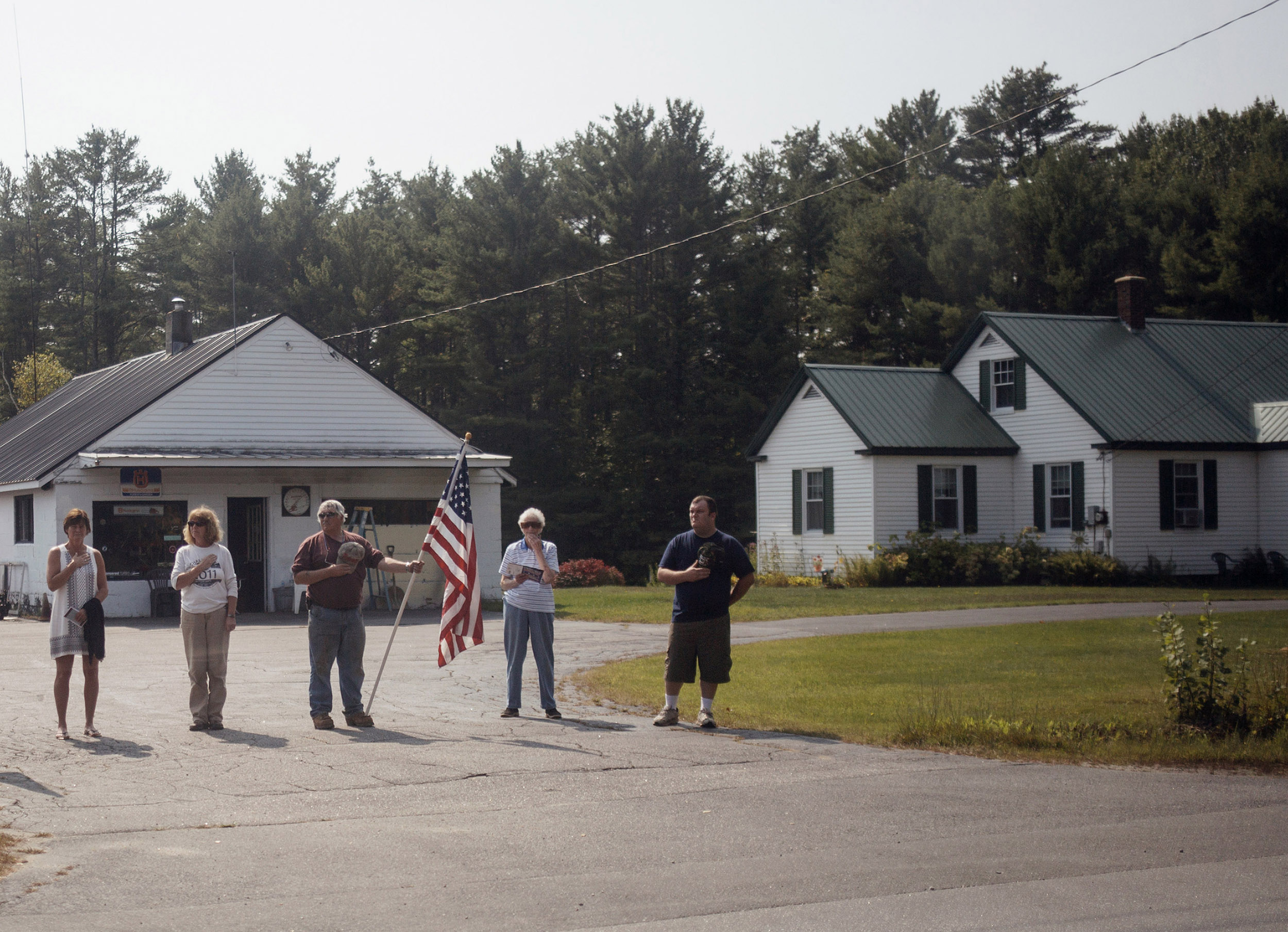 Community members stand alongside the road to pay their respects as Capt. Ben Cross' funeral procession makes its way to Riverside Cemetery in Bethel, Maine. Cross, a 26-year-old Bethel native, was among three Marines killed in August when their MV-22 Osprey crashed into the Coral Sea. His body came home over a month later and hundreds of community members came out to honor him.