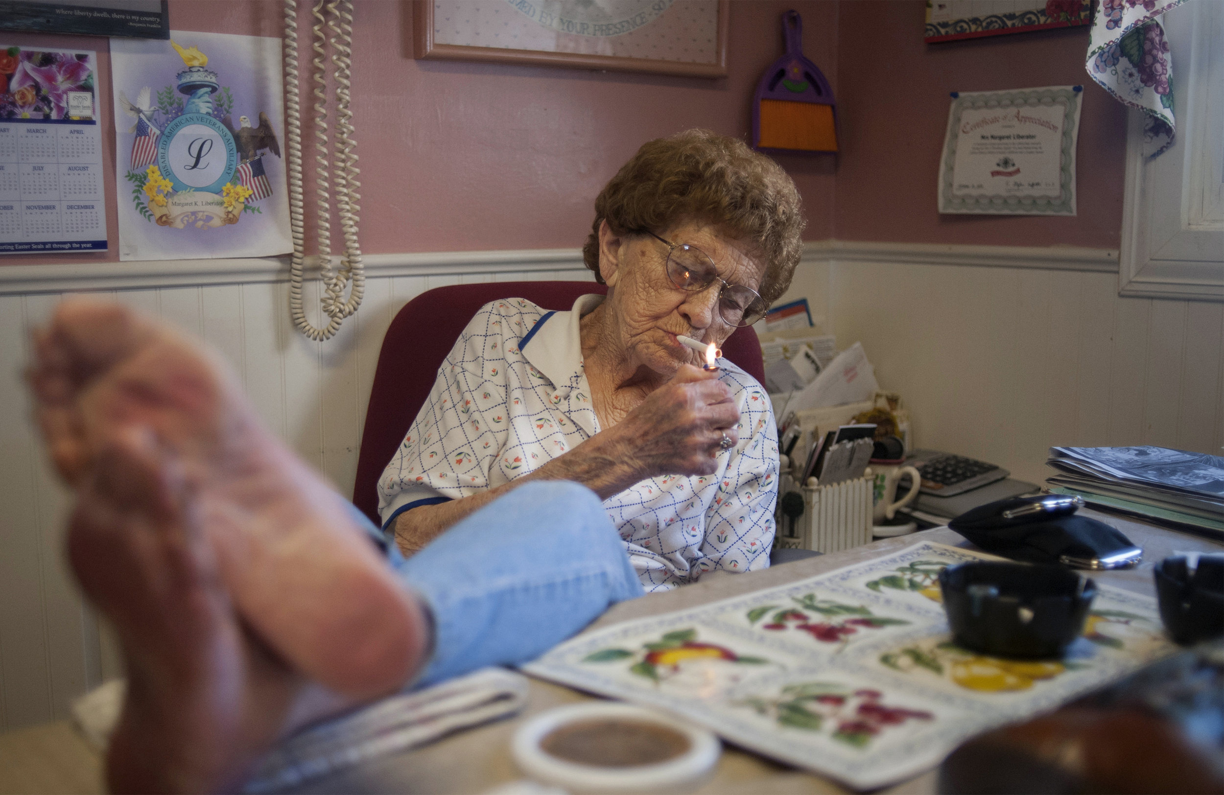 Peg Liberator at her kitchen table in Valentine, Nebraska. Liberator is now 100 years old and has lived in Valentine since the 1940s. She says her key to a long life is a whiskey drink every day.