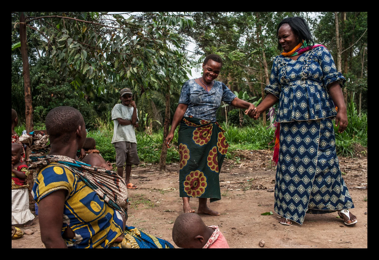 Activist Kahindo Siherya Alphonsine jokes with a Pygmy woman in the village of Upende