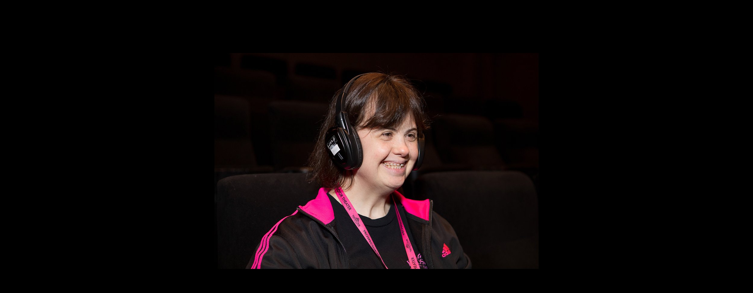 Julie wears a descriptive narrative headset while enjoying a moive.jpg