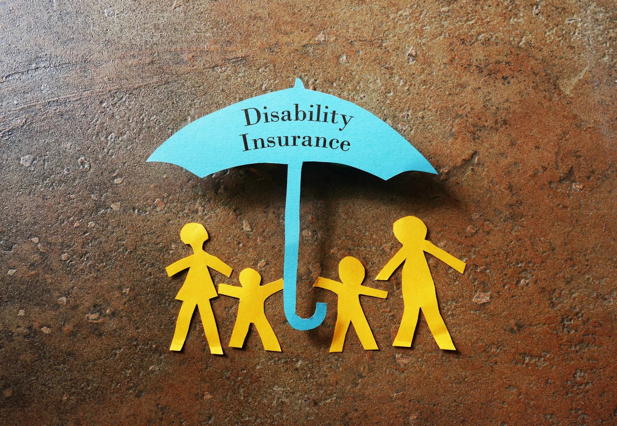 Paper family figures protected under an umbrella labeled “Disability Insurance,” representing income and financial protection.