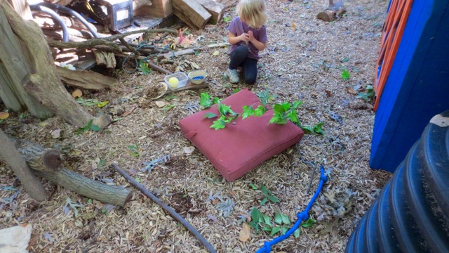 Setting up house in a completely imaginary way with walls indicated by a branch and a rope. The cushion serves as both stove and bed. The time and space to shape this play needs to be roomy and deep.