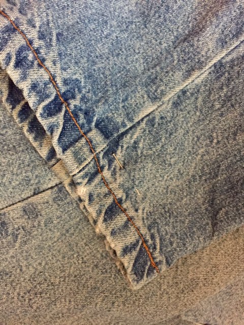 Fold the legs in half - side seam to side sea creating a fold down the centre front go the jeans.