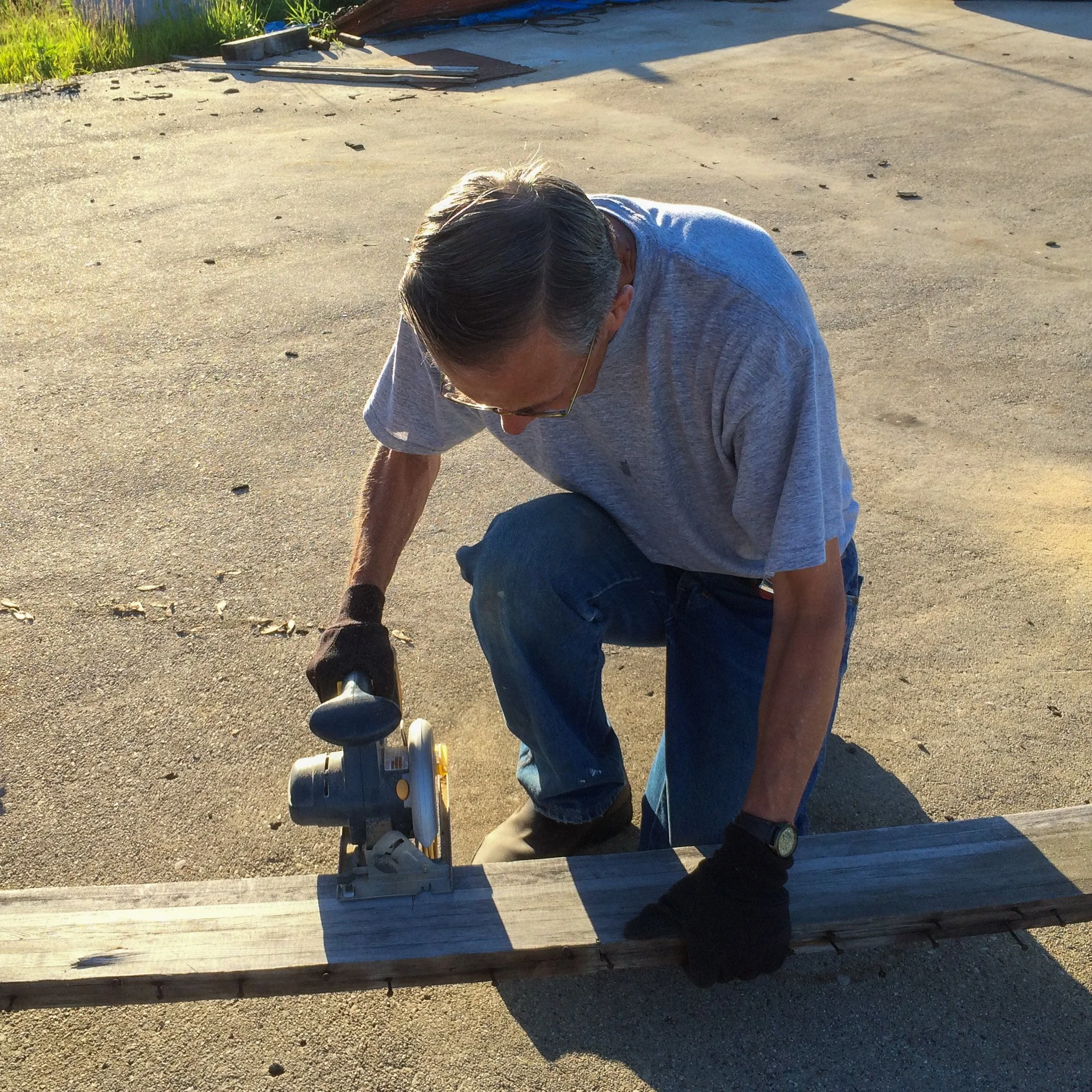 04-dad-rough-cutting-boards-with-circular-saw-on-driveway.jpg