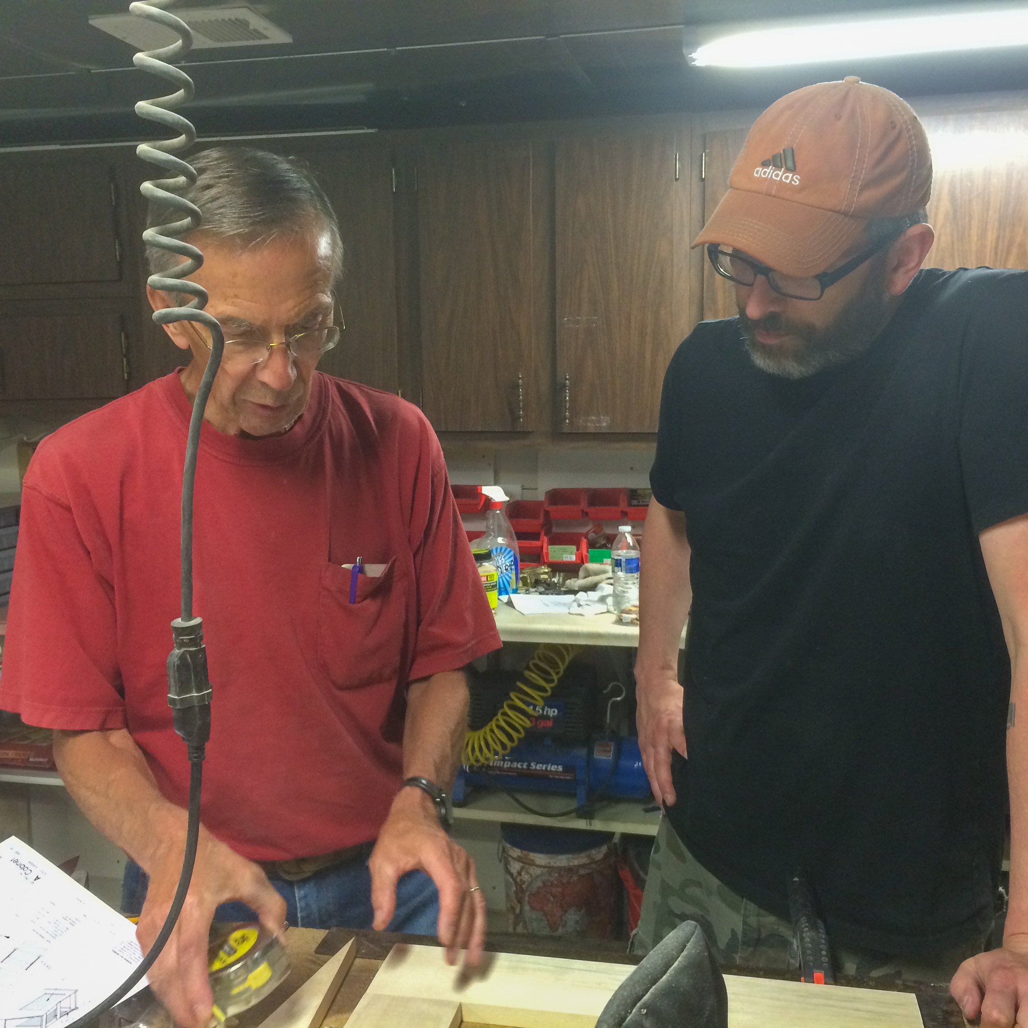 07-dad-and-son-reviewing-plans-with-tape-measure-in-workshop.jpg