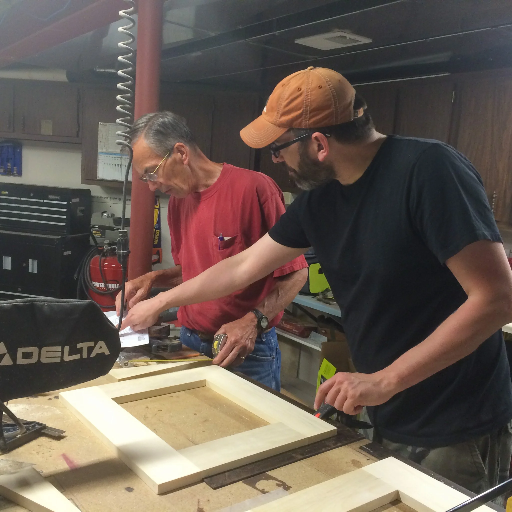 08-dad-and-son-laying-out-desk-frame-components-in-workshop.jpg