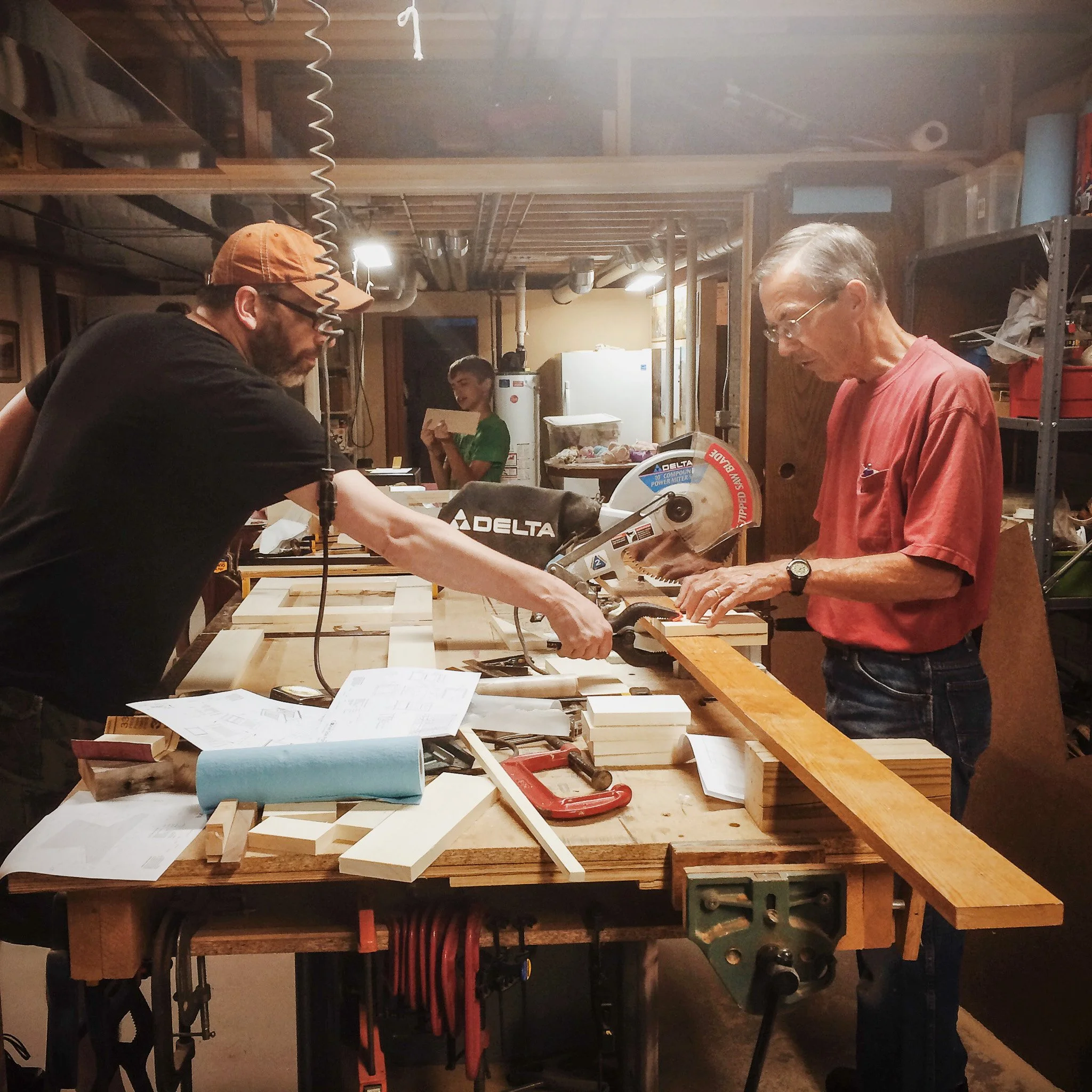 11-dad-and-son-working-at-miter-saw-with-desk-plans-visible.jpg