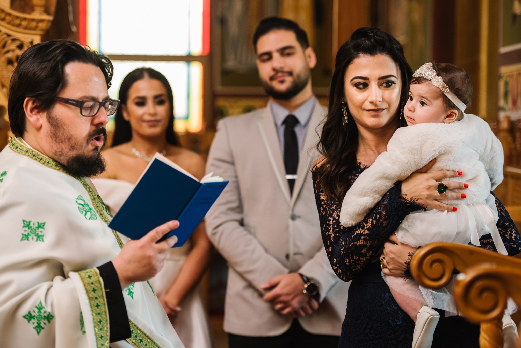Priest and baby during christening service