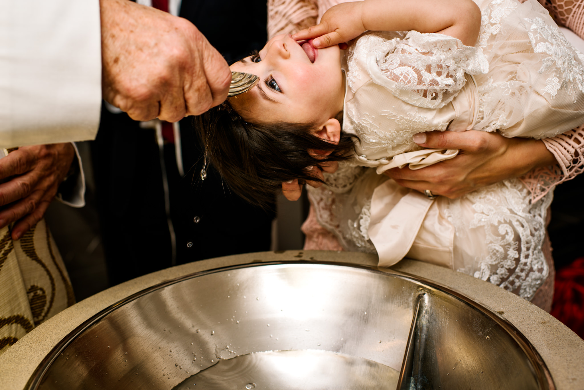 Baptism photo of water splashing on baby's head
