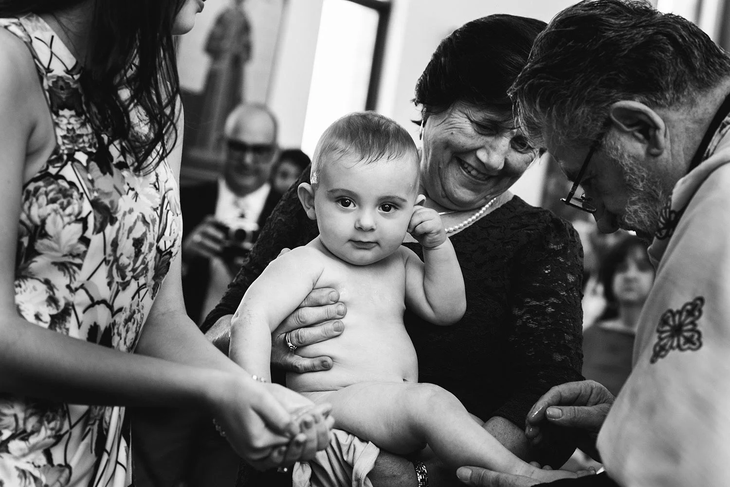 Baby looks at camera while being baptised