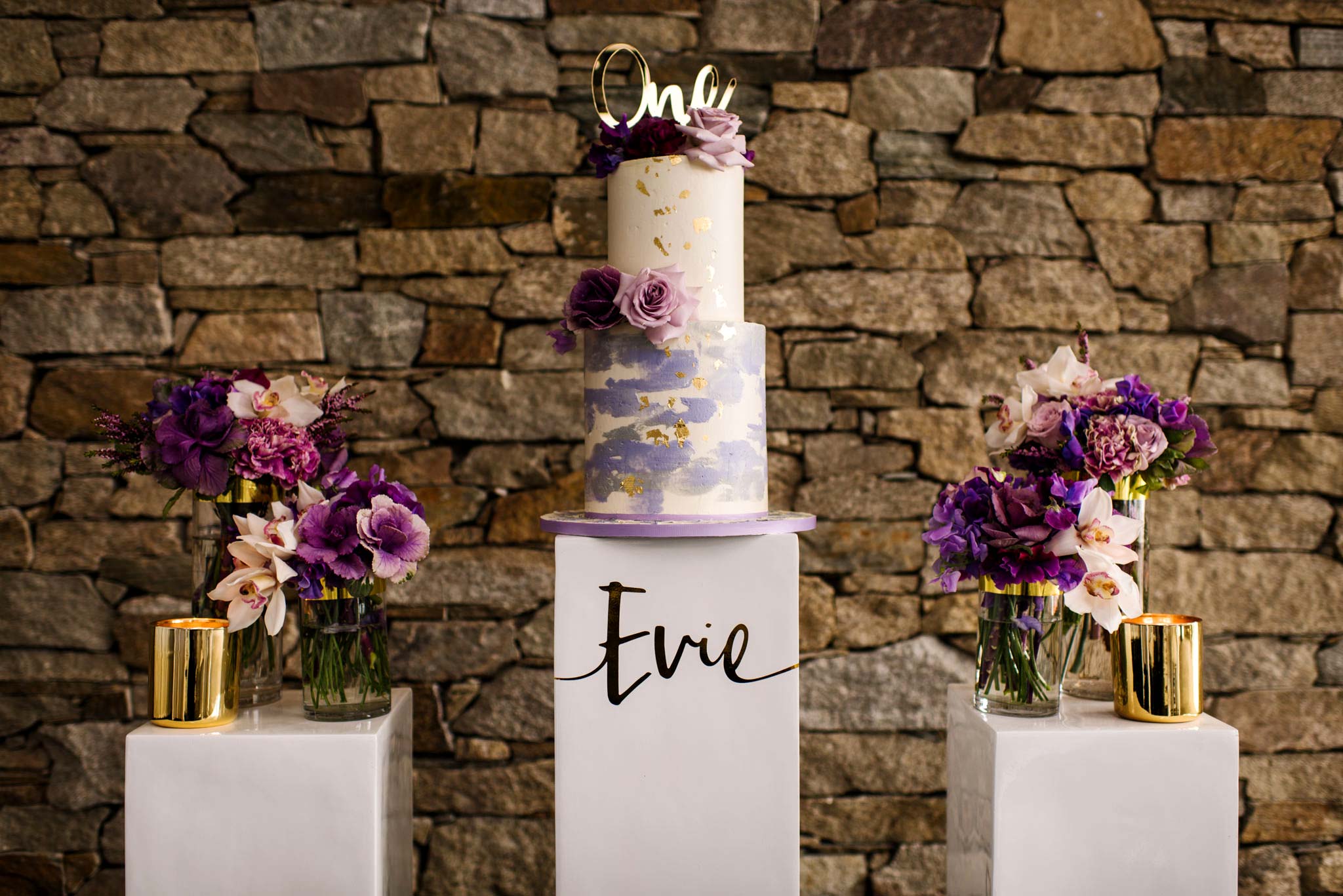 Tiered cake and flowers in vases at Bianco christening venue