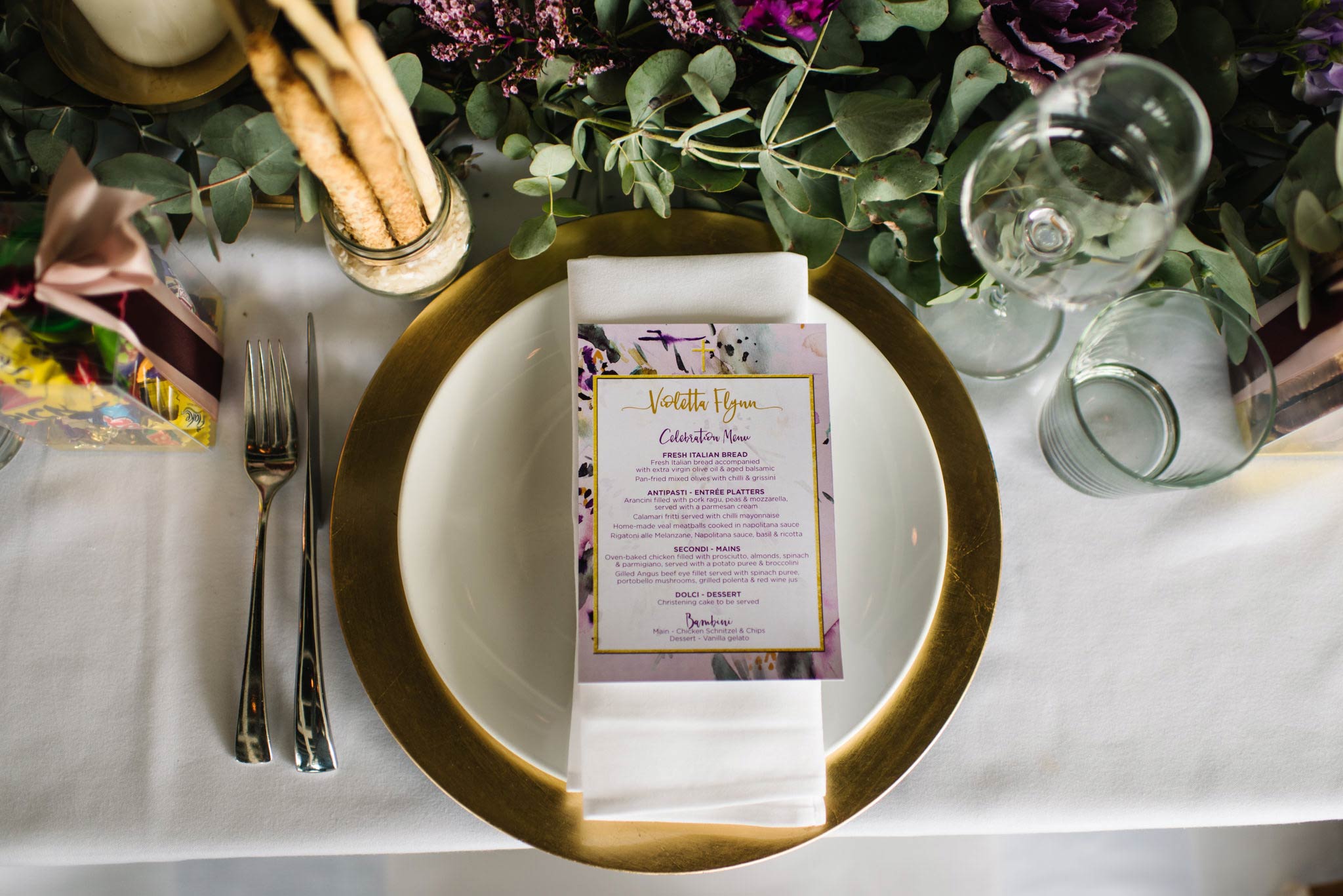 Table setting with gold rimmed plates at Bianco christening venue