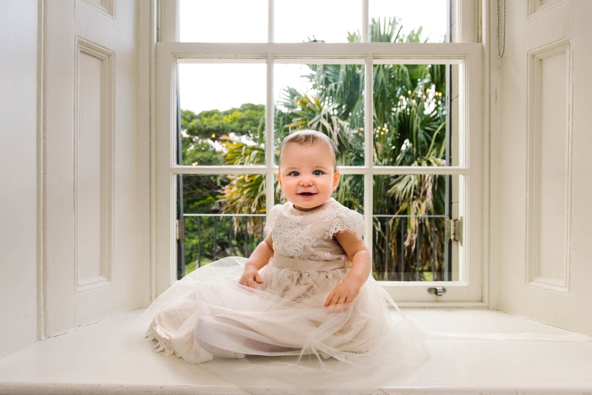 Baby in christening gown with sash windows at Dunbar House