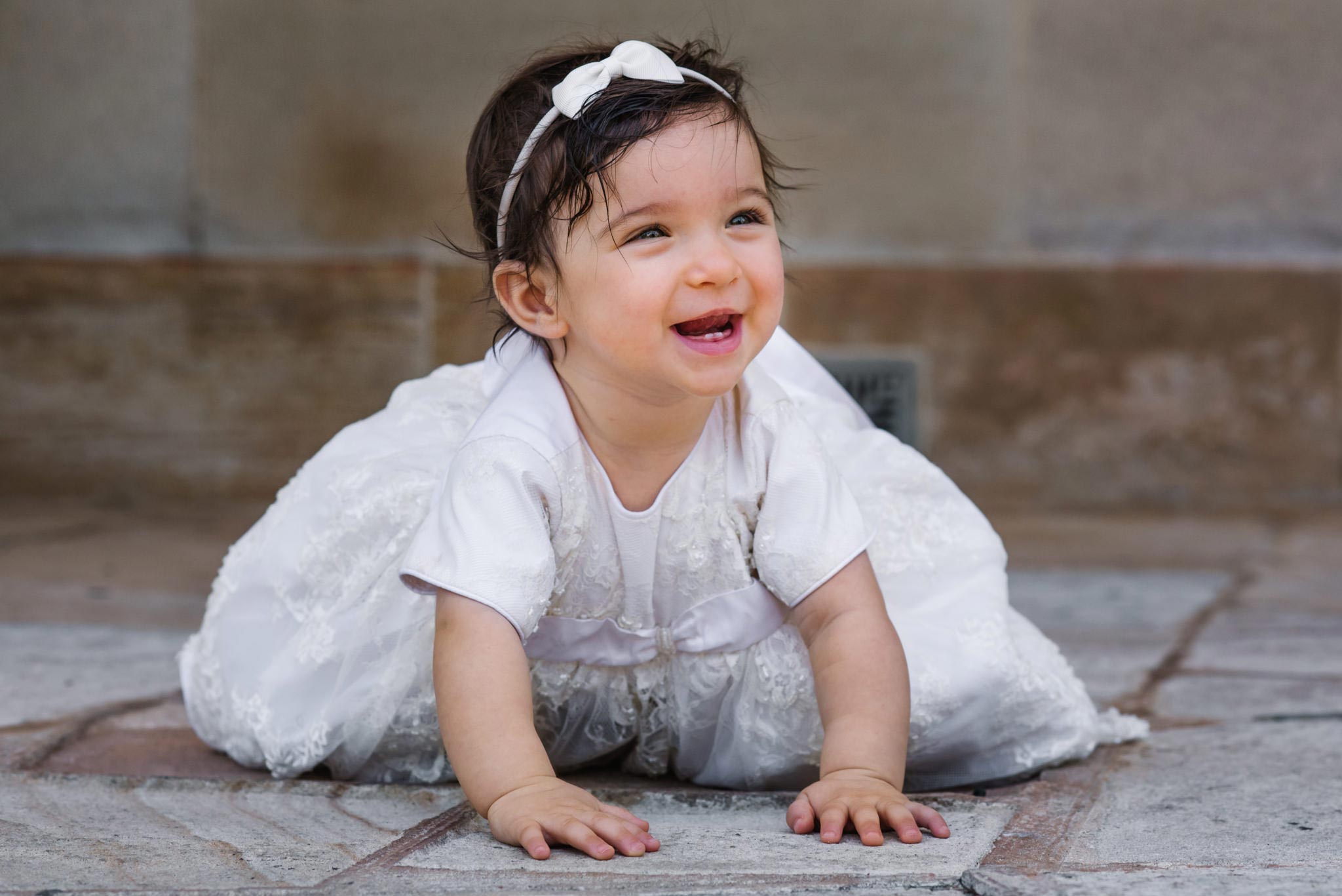 Smiling baby in christening gown at Oatlands House