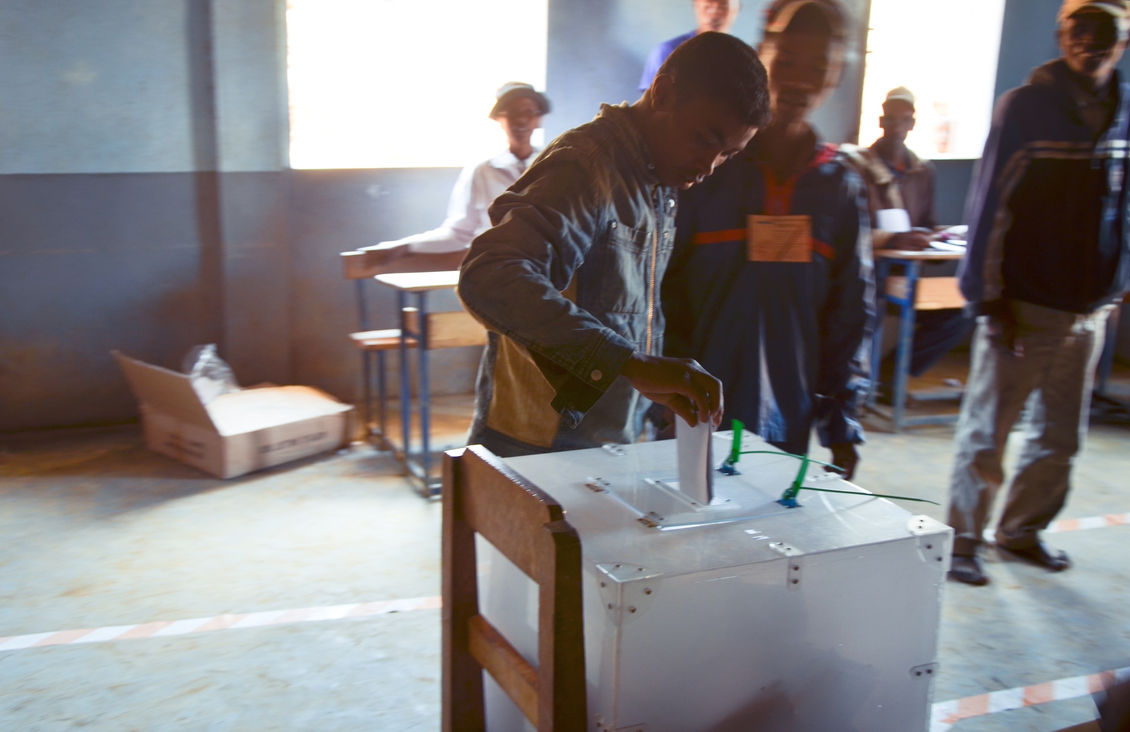A young man drops his vote in the ballot box. Photo: Alizé Carrère
