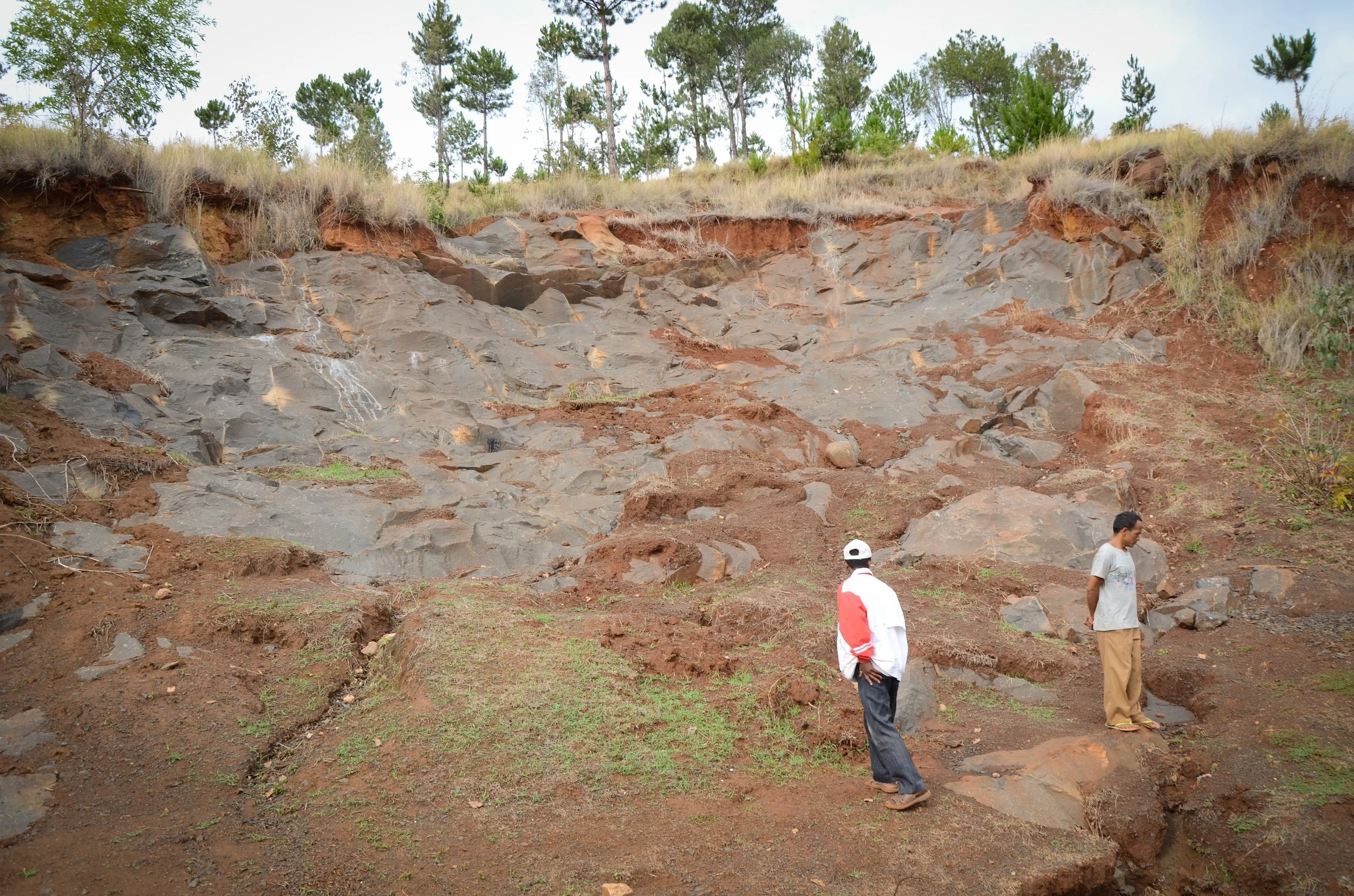 Walking through the upper left half of the lavaka. This lavaka was particularly unusual as the displacement of soil revealed an extensive layer of bed rock, making stabilization efforts through the planting of trees and vegetation near impossible. Photo: Alizé Carrère