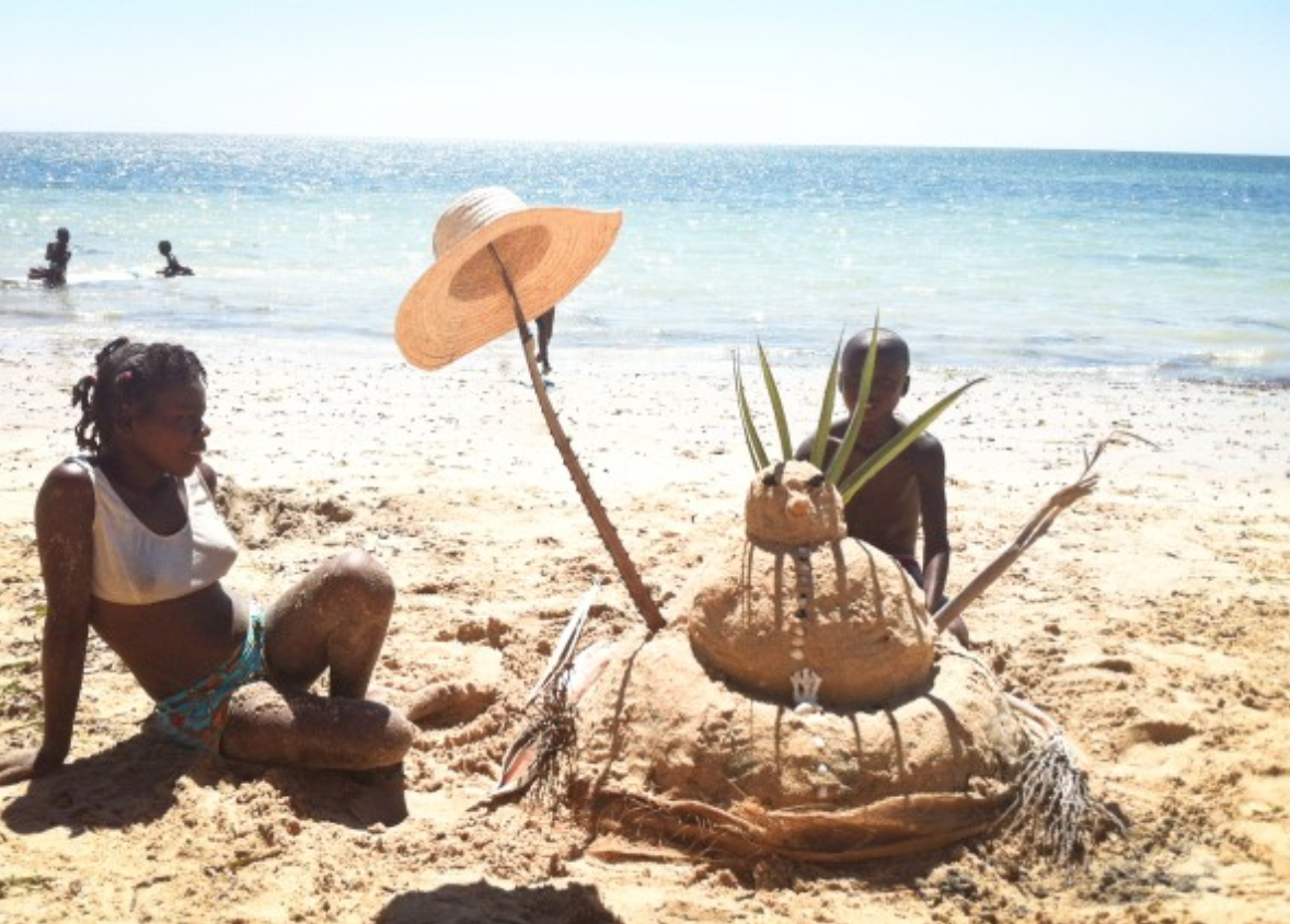 Showing local children how to make a "sandman". Photo © Alizé Carrère