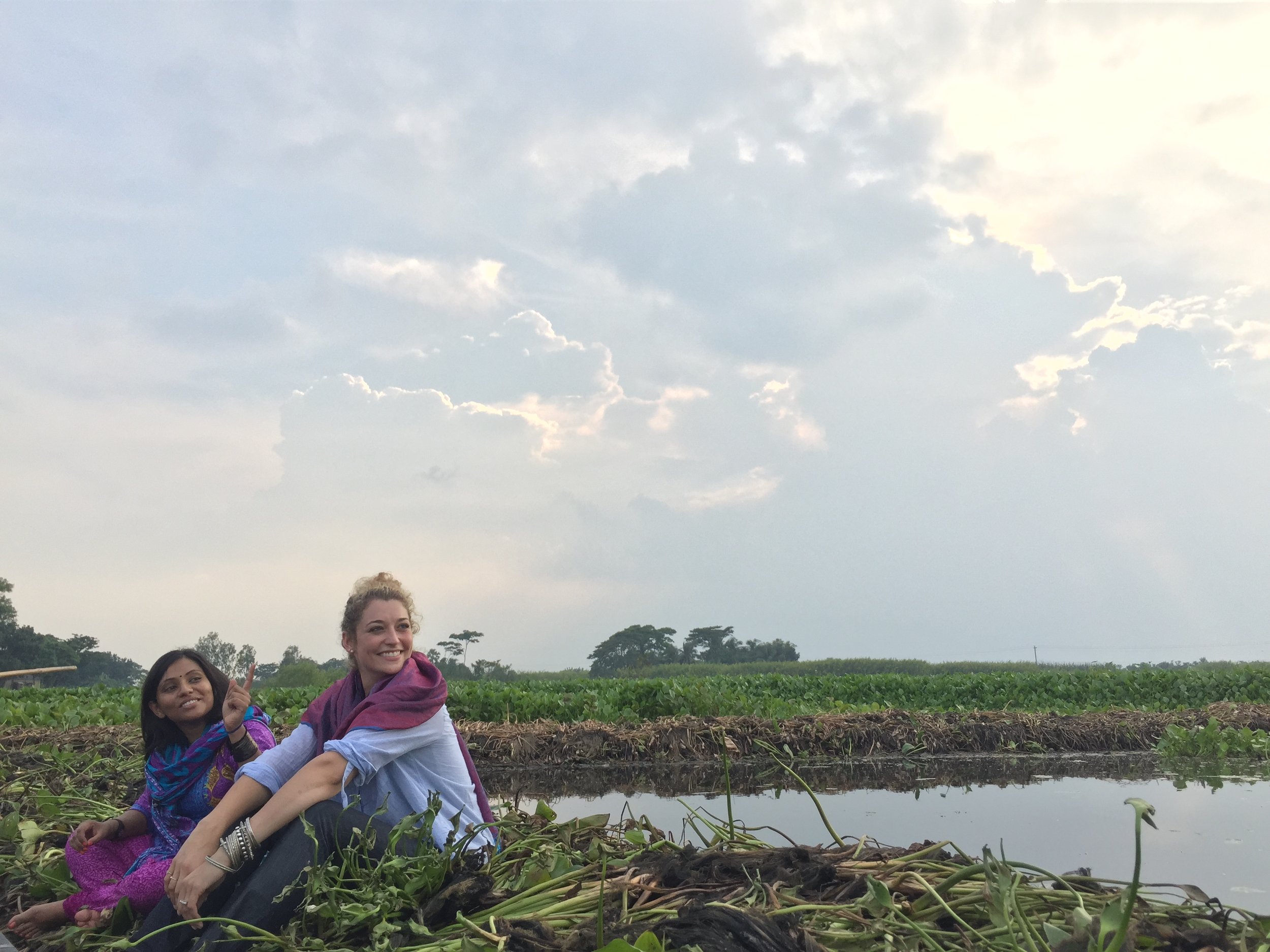 Buoyant fields made of plants and manure can support crops in Bangladesh. Sitting on one of the organic floating gardens with Bangladeshi journalist Tania Rashid. Photo by Katia Nicolova. 