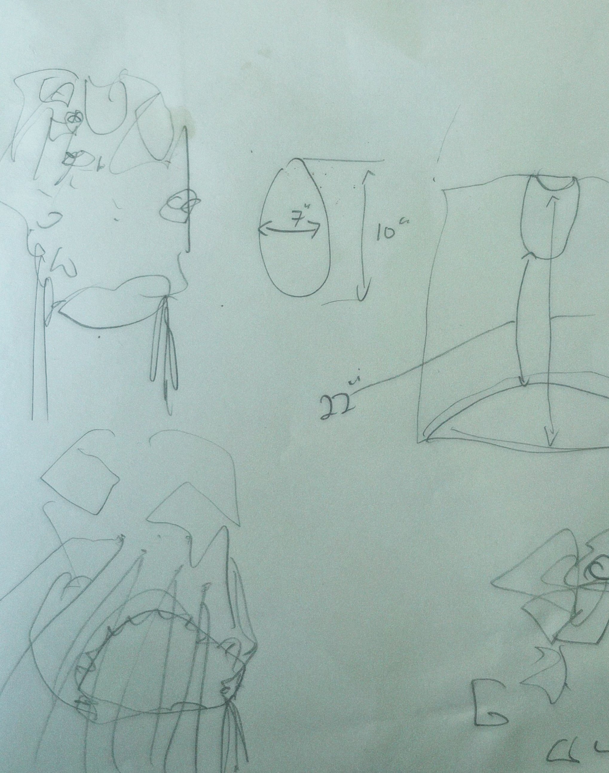 Various hand-drawn sketches and measurements on white paper, including an oval shape with dimensions 7 inches by 10 inches, a vertical line measuring 22 inches, and a face sketch with exaggerated features.