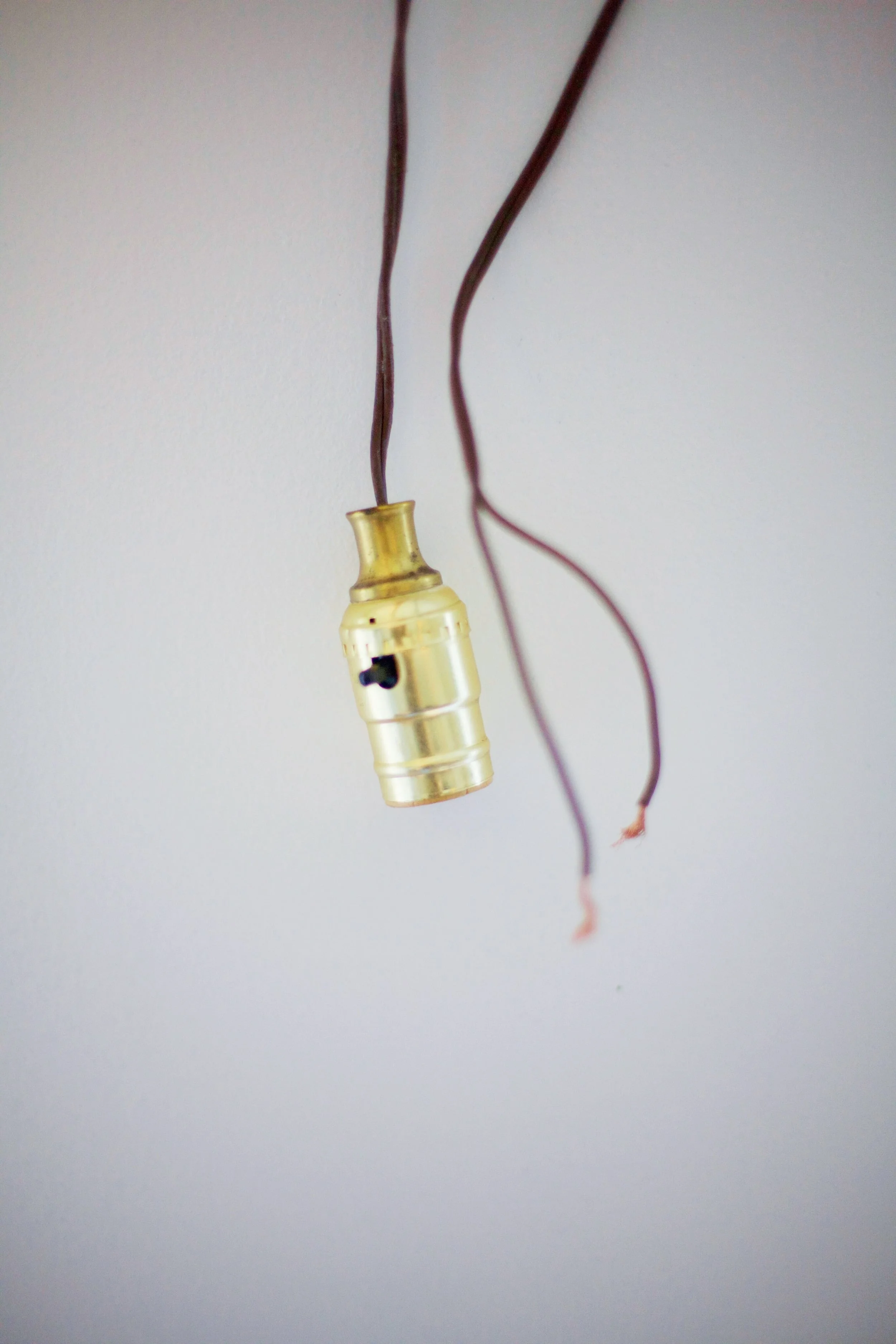 . I cut off the male plug end from the lamp cord, pulled out the light socket with the cord still attached, and stripped the ends. *Note, if you're installing this yourself and using a lamp cord like the one below, there will be grooves on one of the rubber shilding of the wire. That one will be your hot wire, the smooth one will be your neutral*.