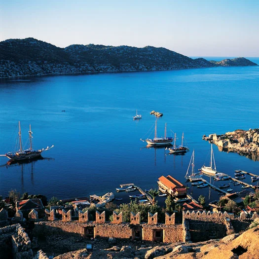 Turkey luxury travel: Crusader castle wall with modern gulets in harbor of Germiler Adasi below. (Wes Walker)