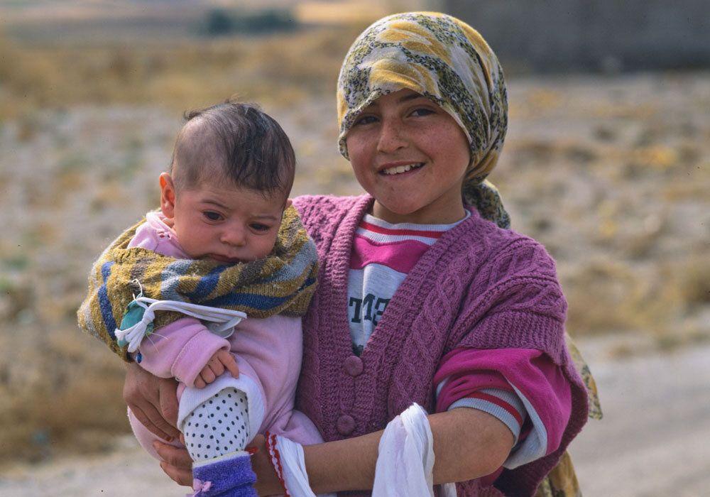Turkish-girl-holds-infant.jpg