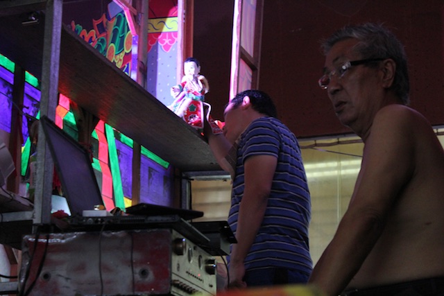  Men operating the hand puppets behind the stage.