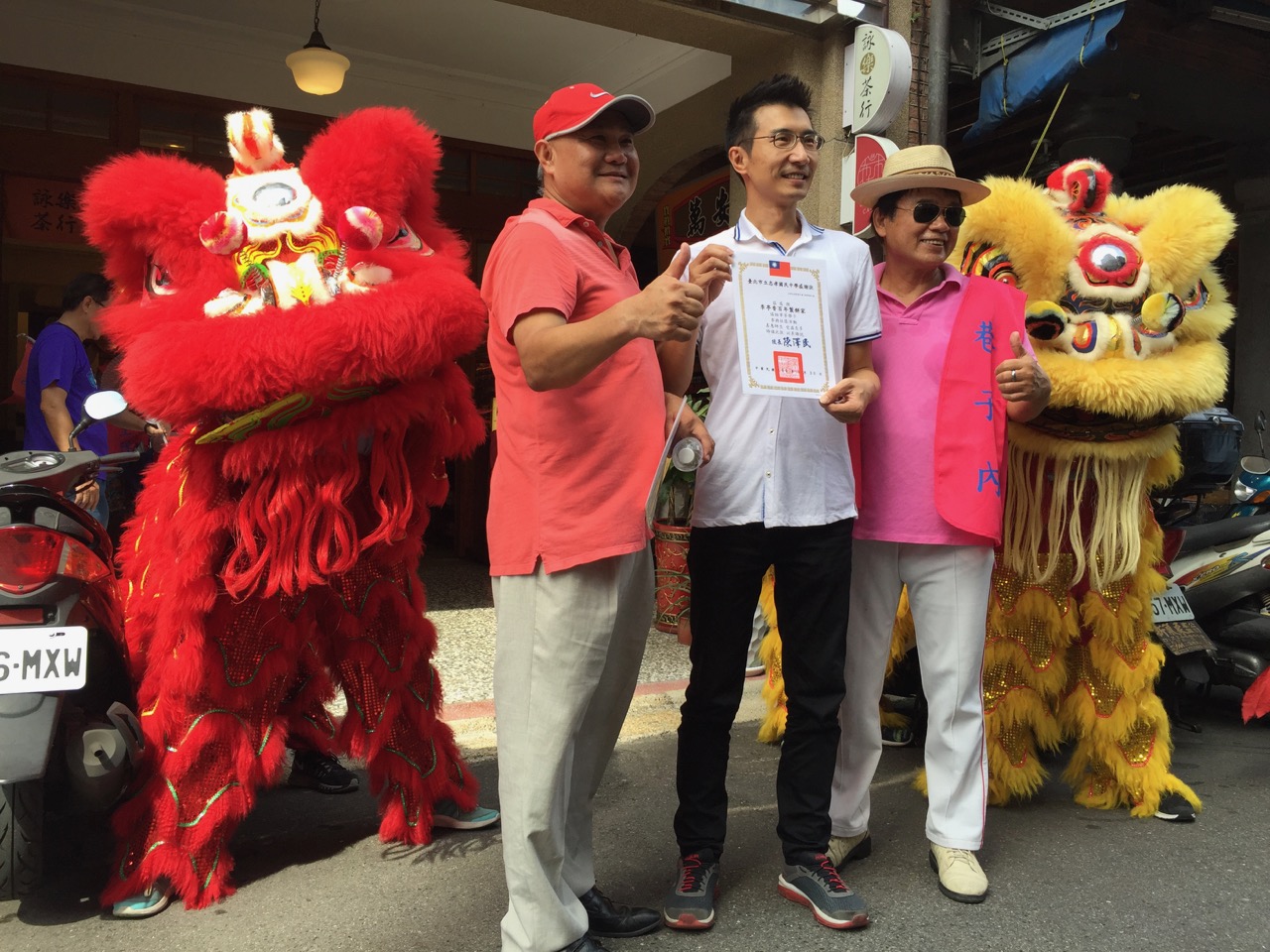 Dragon and lion posing with Lee Bakery owner, Mr. Lee, after they blessed his shop with a dance
