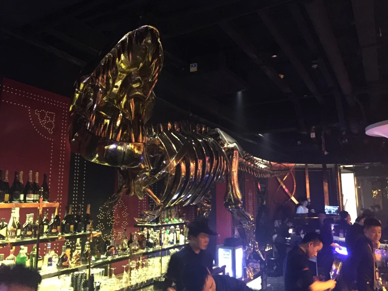 A chrome dinosaur haunts the bar at Mix club in Gongti